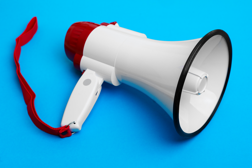 A white and red megaphone on a blue background, symbolizing the power of paid advertising to amplify business messages in Jupiter, Florida.